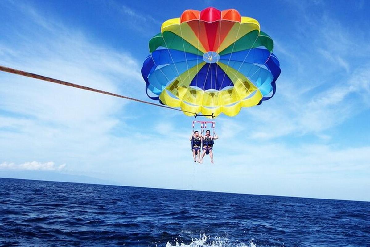 Dva lidé jsou na padáku nad oceánem