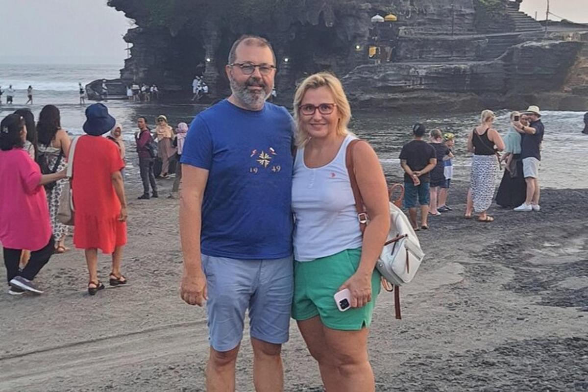 a man and a woman standing on the beach