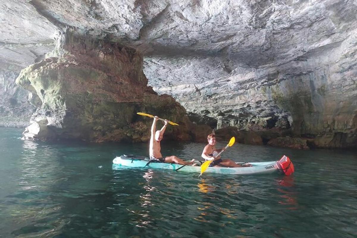 dua orang sedang berbaring di atas kayak di dalam air