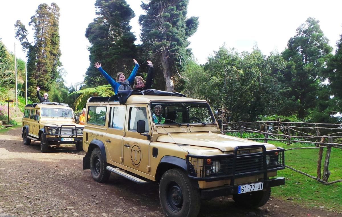two people are sitting on top of a jeep