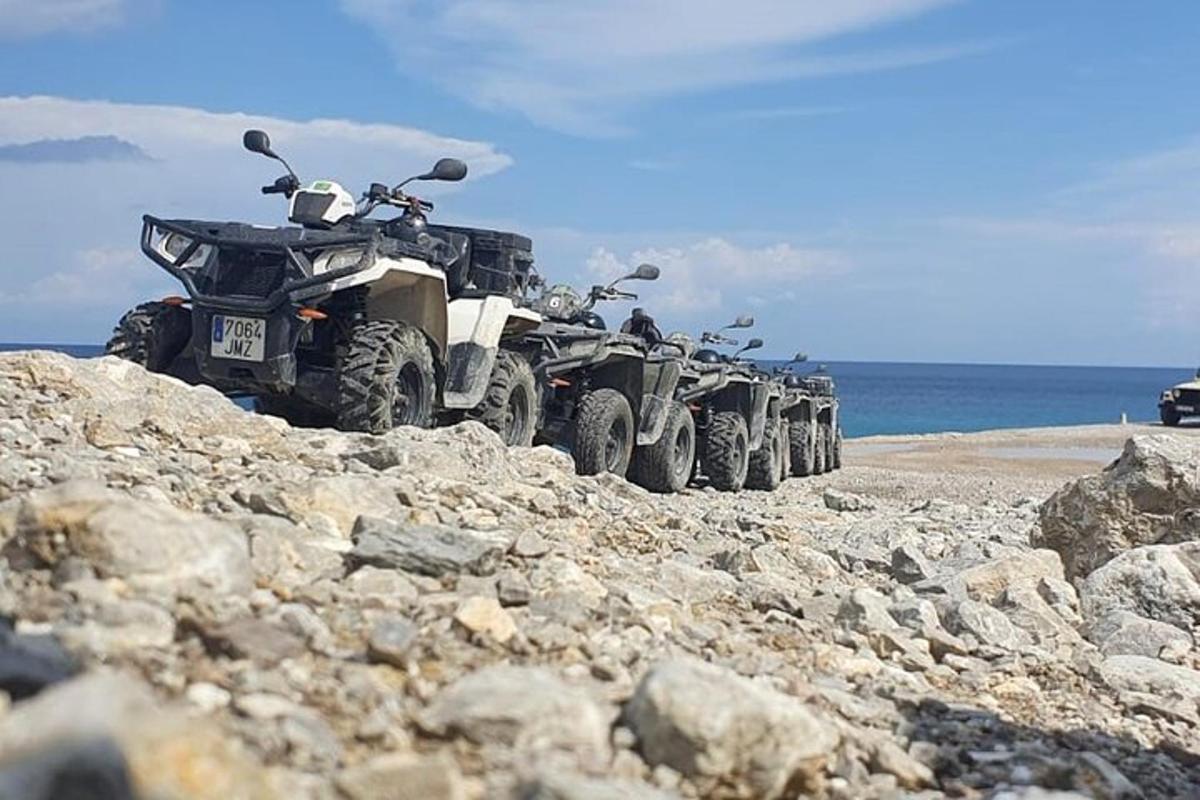 un rând de ATV-uri parcate pe o plajă stâncoasă