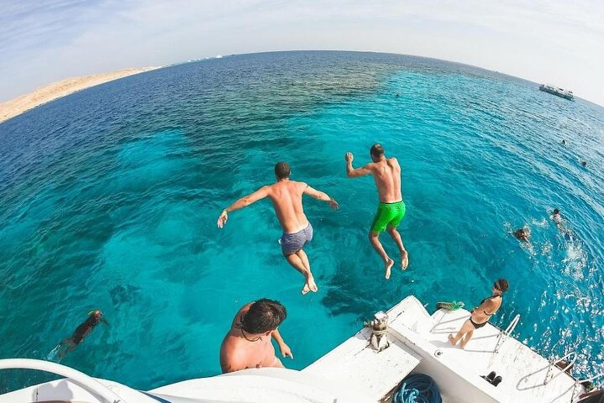 un gruppo di persone che saltano in acqua da una barca