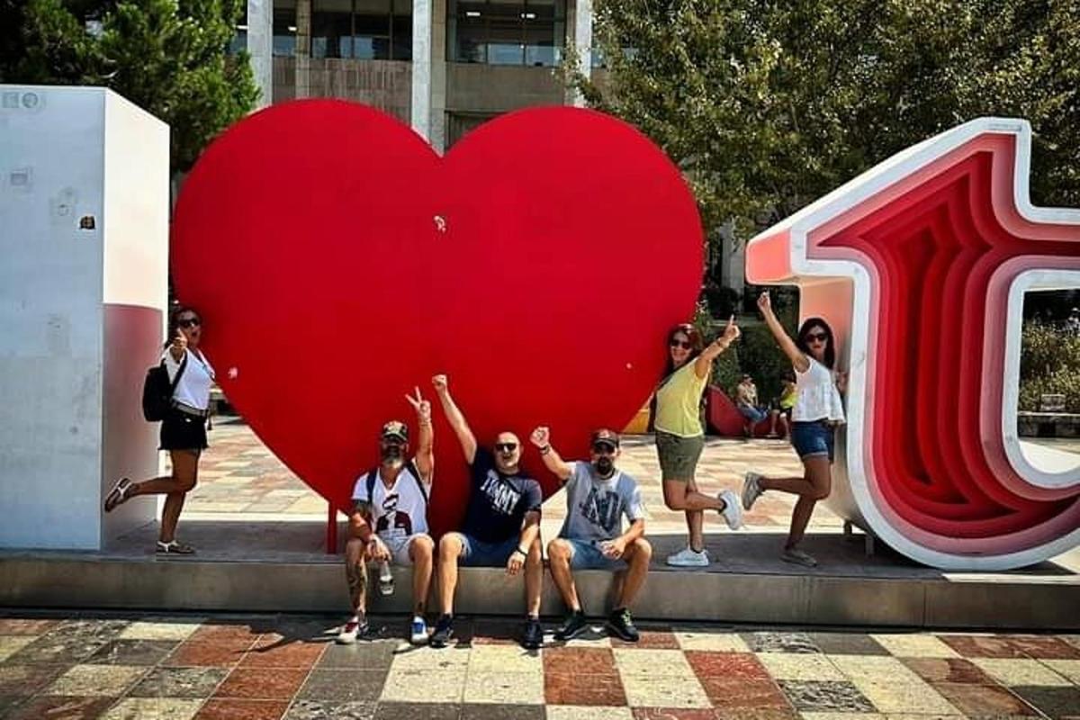 Un grupo de personas sentadas frente a un gran corazón.