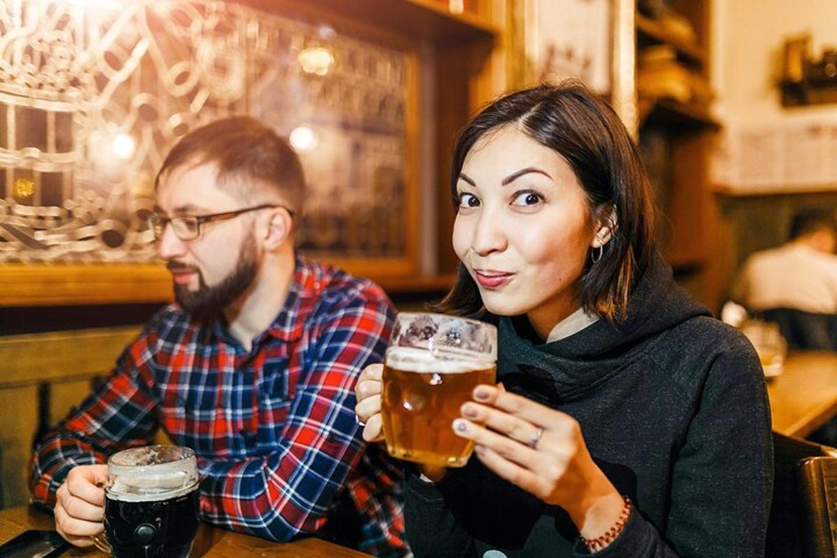 dva lidé sedí u stolu a pijí pivo