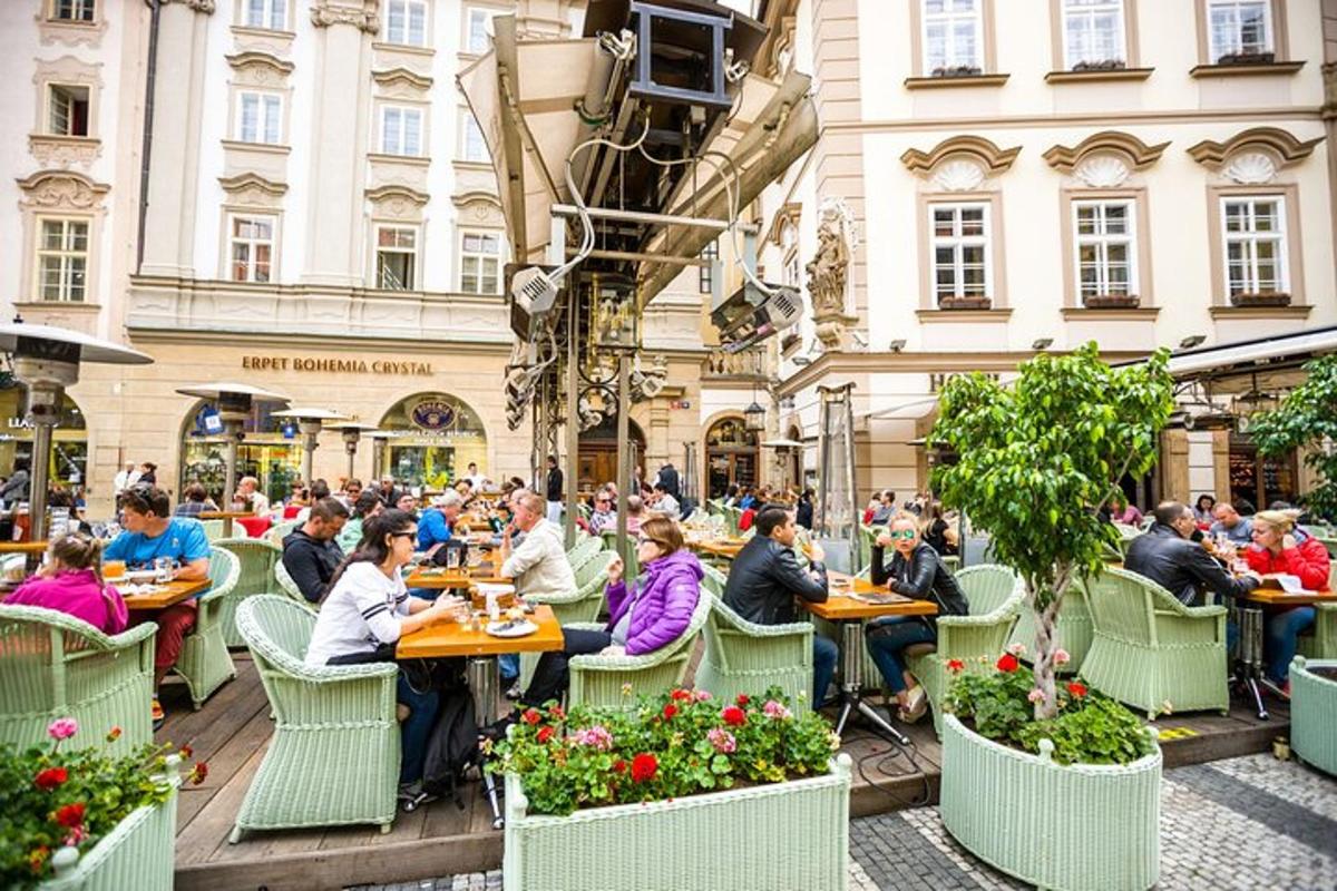 skupina lidí sedících u stolů ve venkovní restauraci
