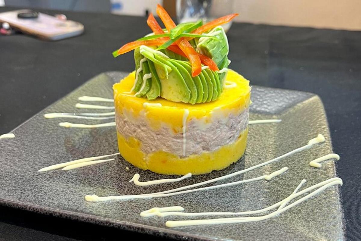 en gul dessert med gulerødder ovenpå på et sort bord