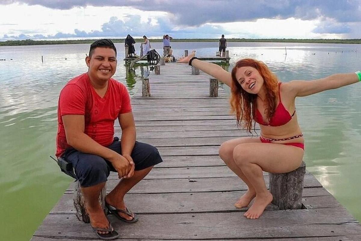 um homem e uma mulher sentados em uma doca na água