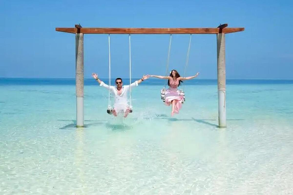 ein Mann und eine Frau sitzen auf einer Schaukel im Wasser