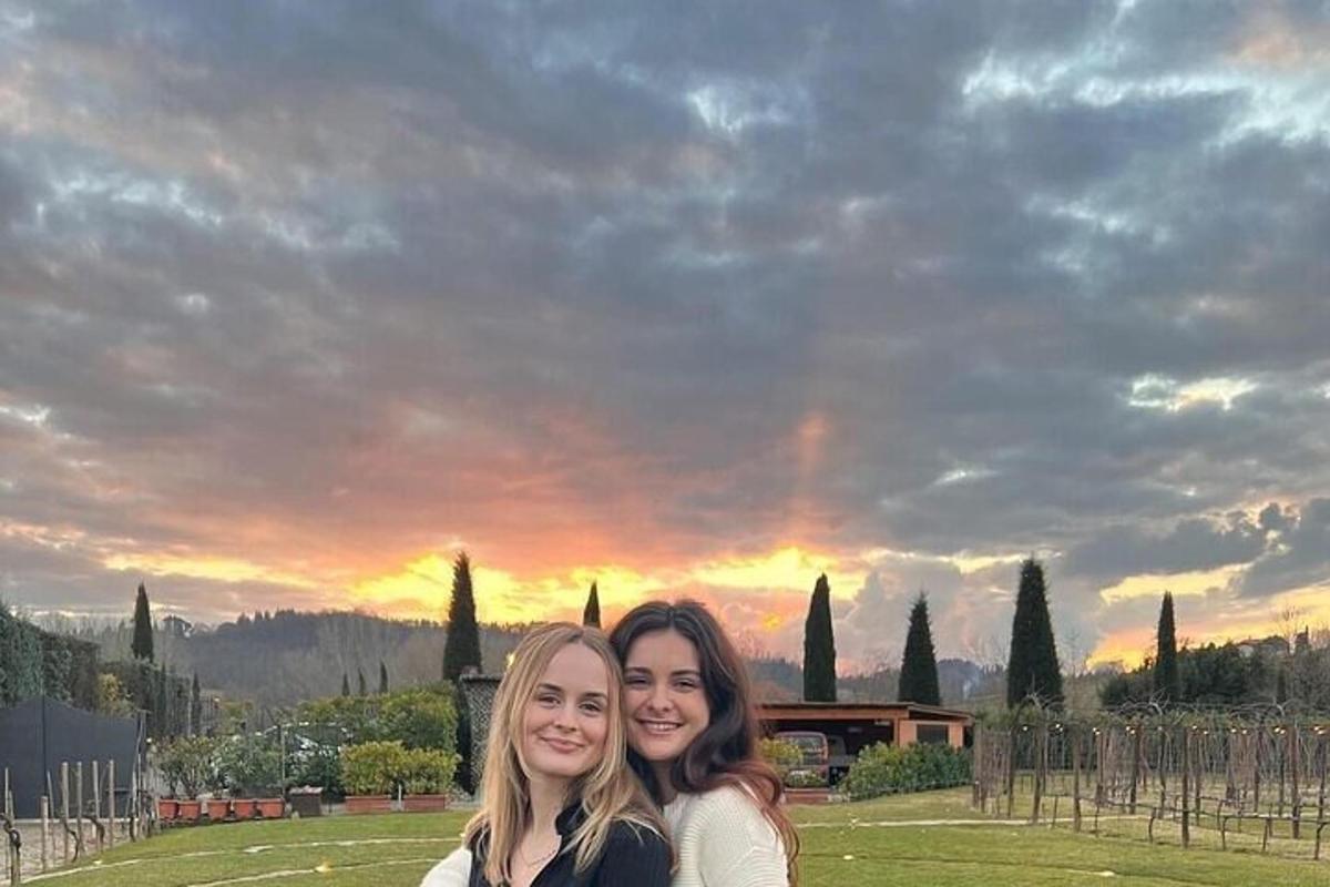 dues dones posant per a una foto davant d'una posta de sol