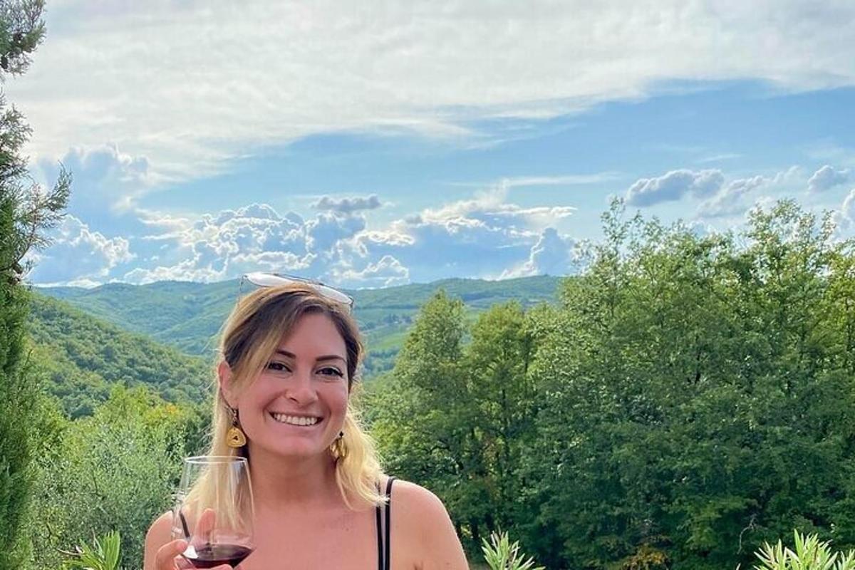una donna tiene in mano un bicchiere di vino
