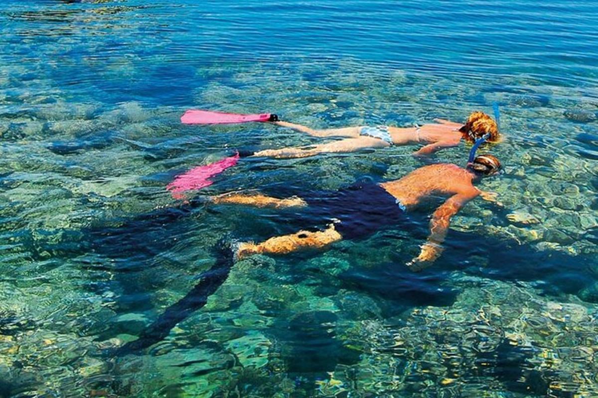 tre persone che nuotano nell'acqua nell'acqua