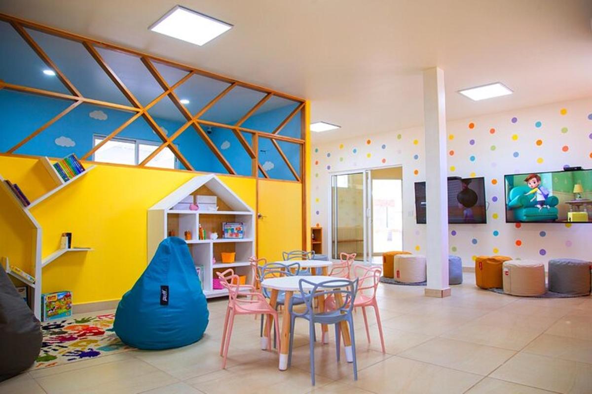 una sala amb taula i cadires i una zona de jocs