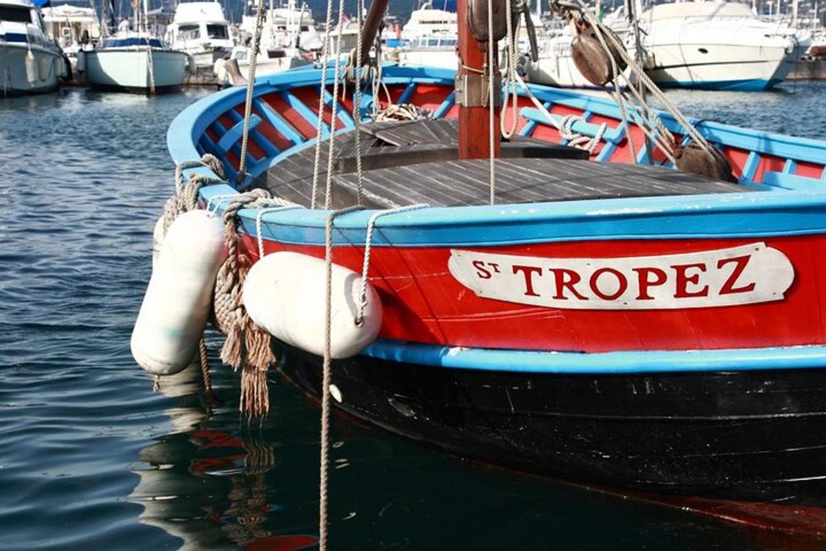 μια κόκκινη και μπλε βάρκα που κάθεται στο νερό