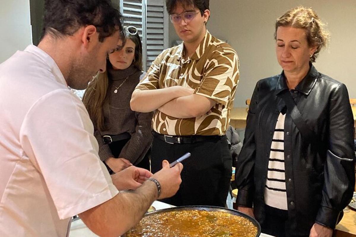 a man standing next to a woman preparing food