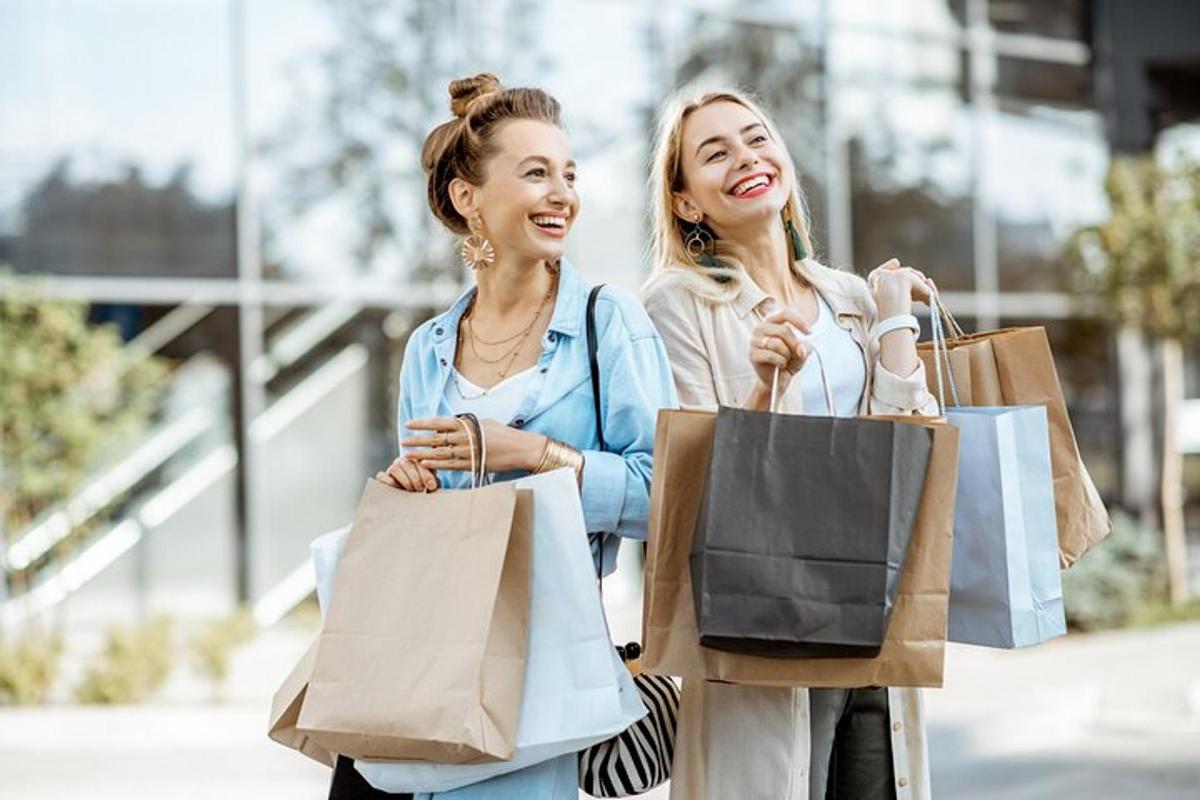 två kvinnor som går med shoppingkassar i en stad