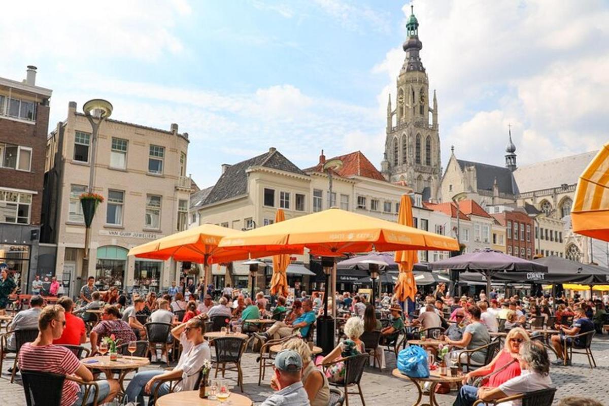 duża grupa ludzi siedząca przy stołach na ulicy