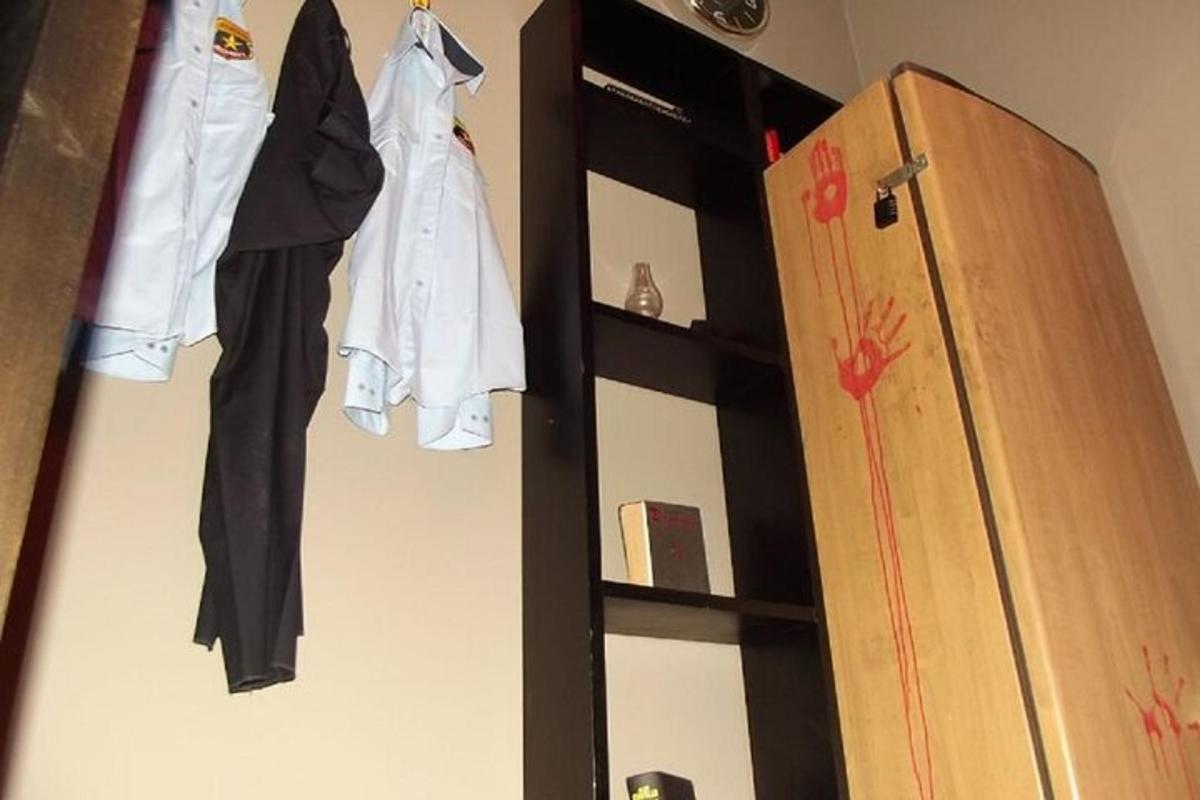 uno scaffale nero con vestiti sopra accanto a un frigorifero