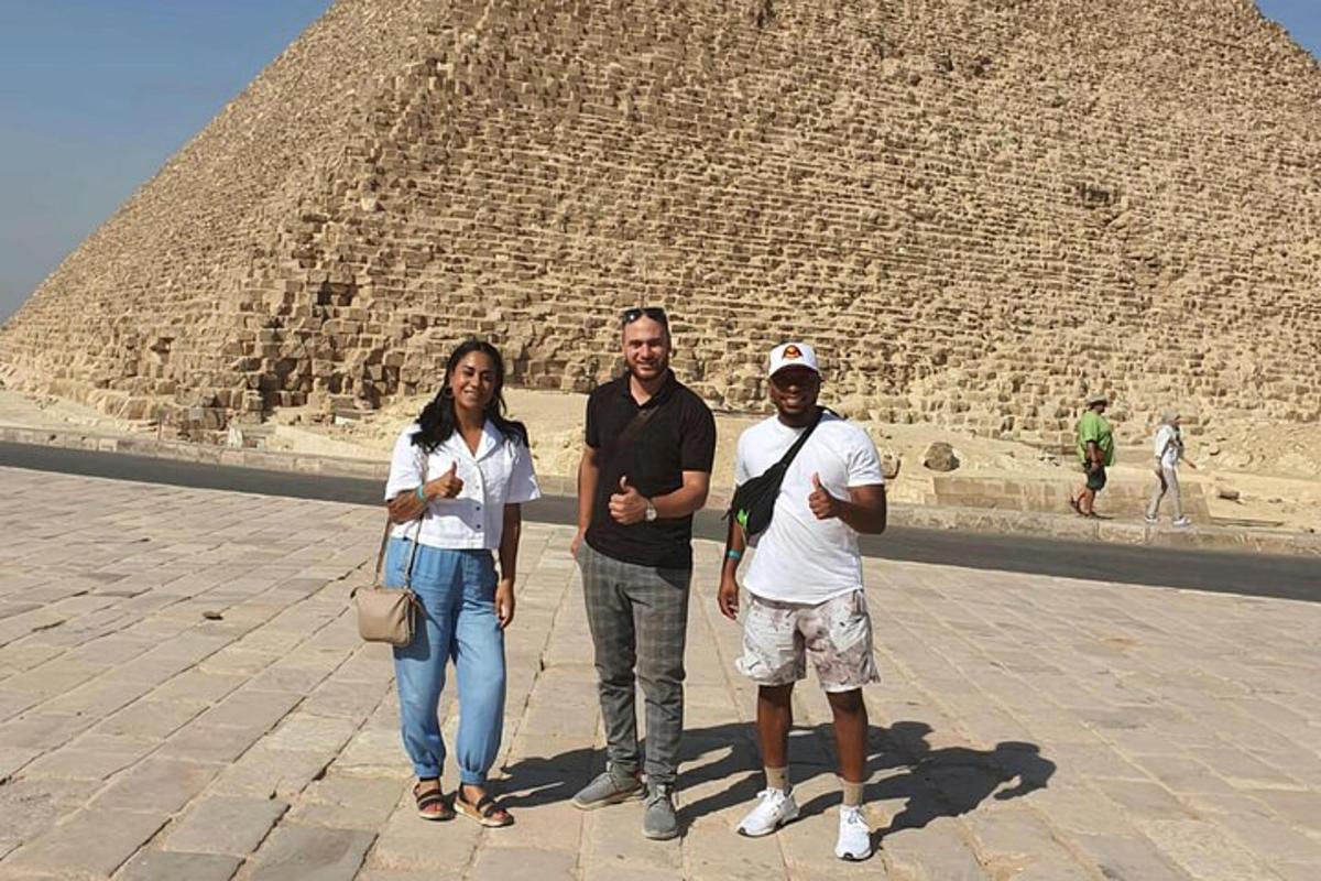 tre persone in piedi davanti a una piramide