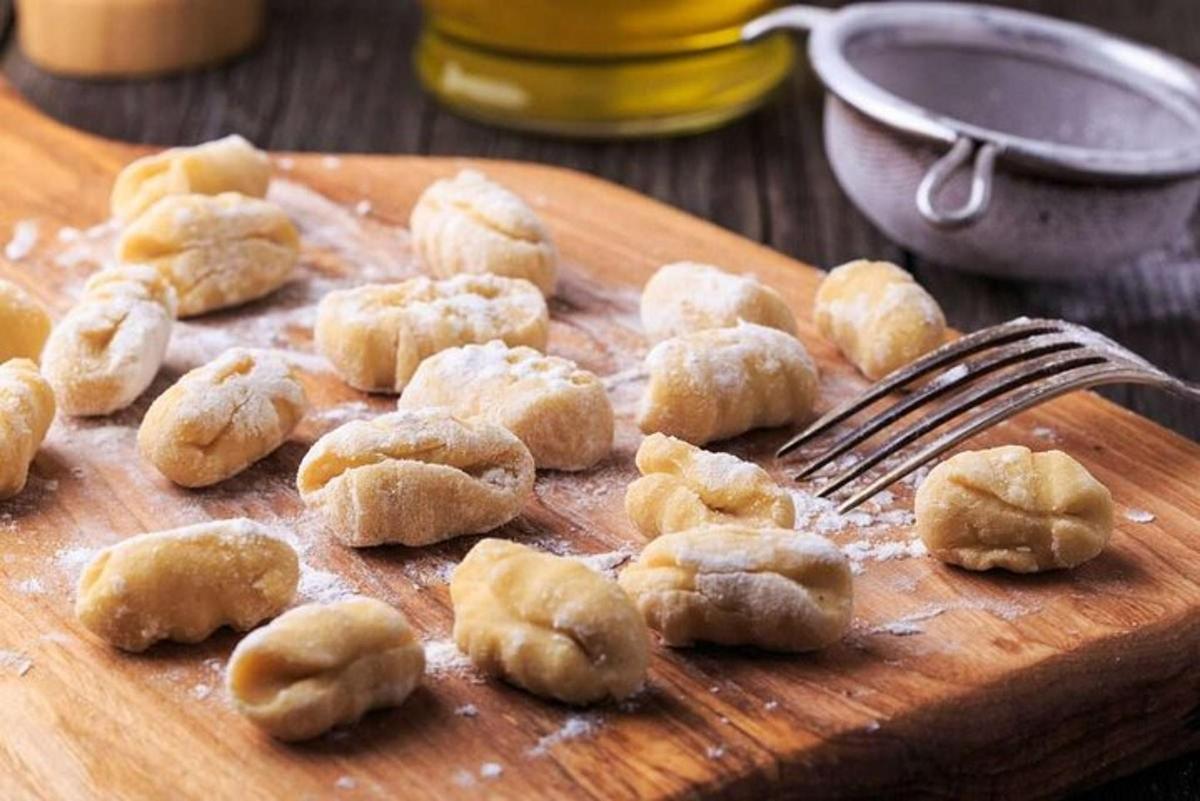 una taula de tallar de fusta amb un grapat de donuts i una forquilla