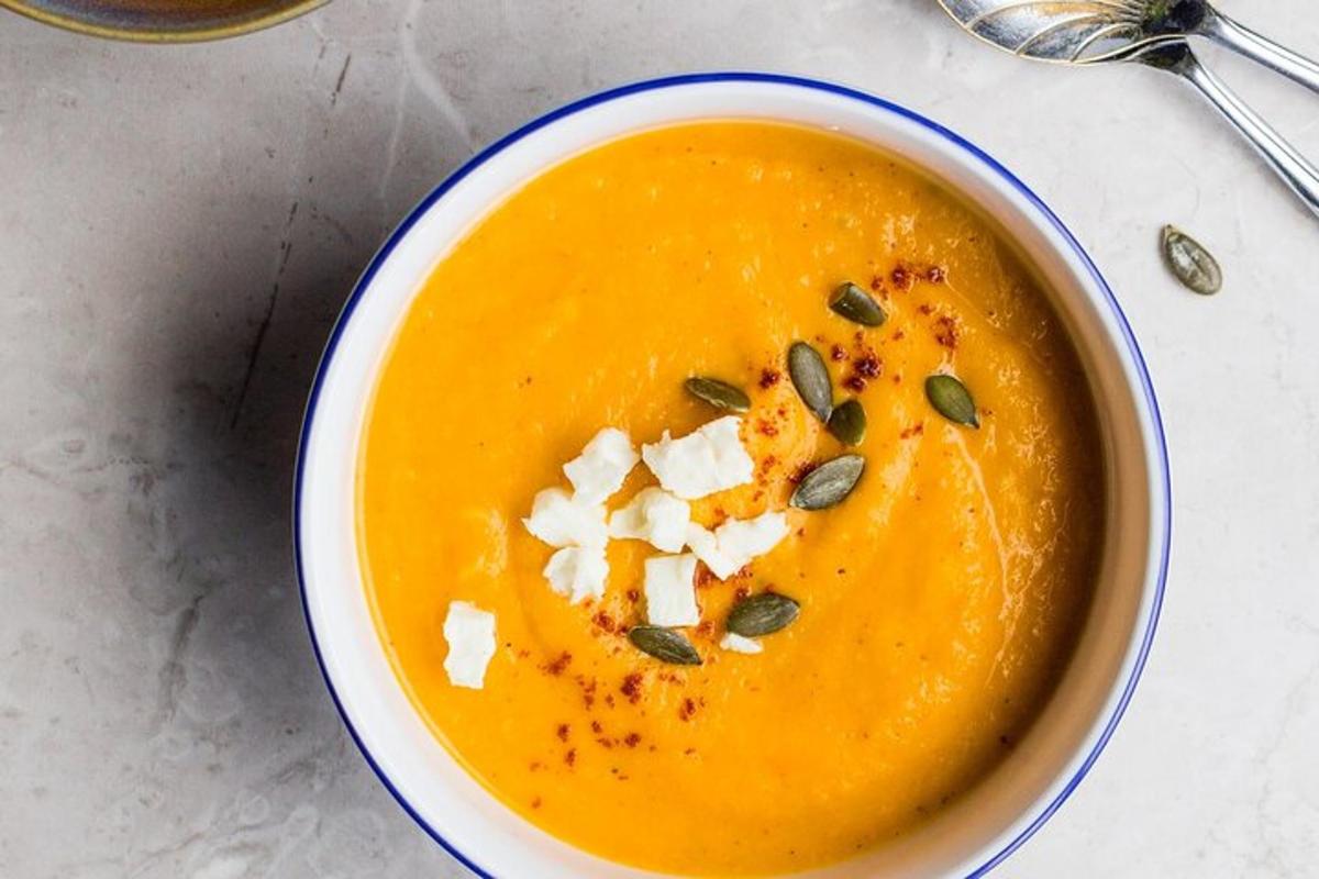 una ciotola di zuppa di zucca con formaggio e semi di zucca