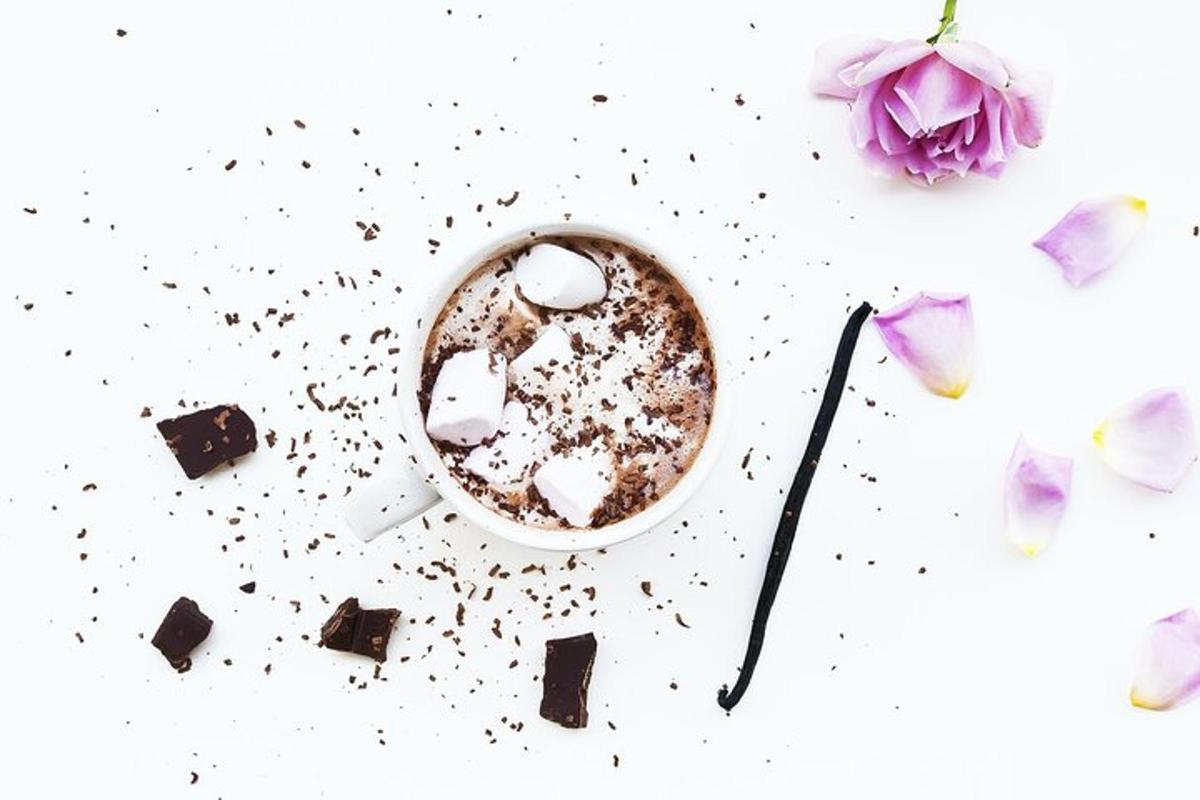 una tazza di caffè e fiori su un tavolo bianco
