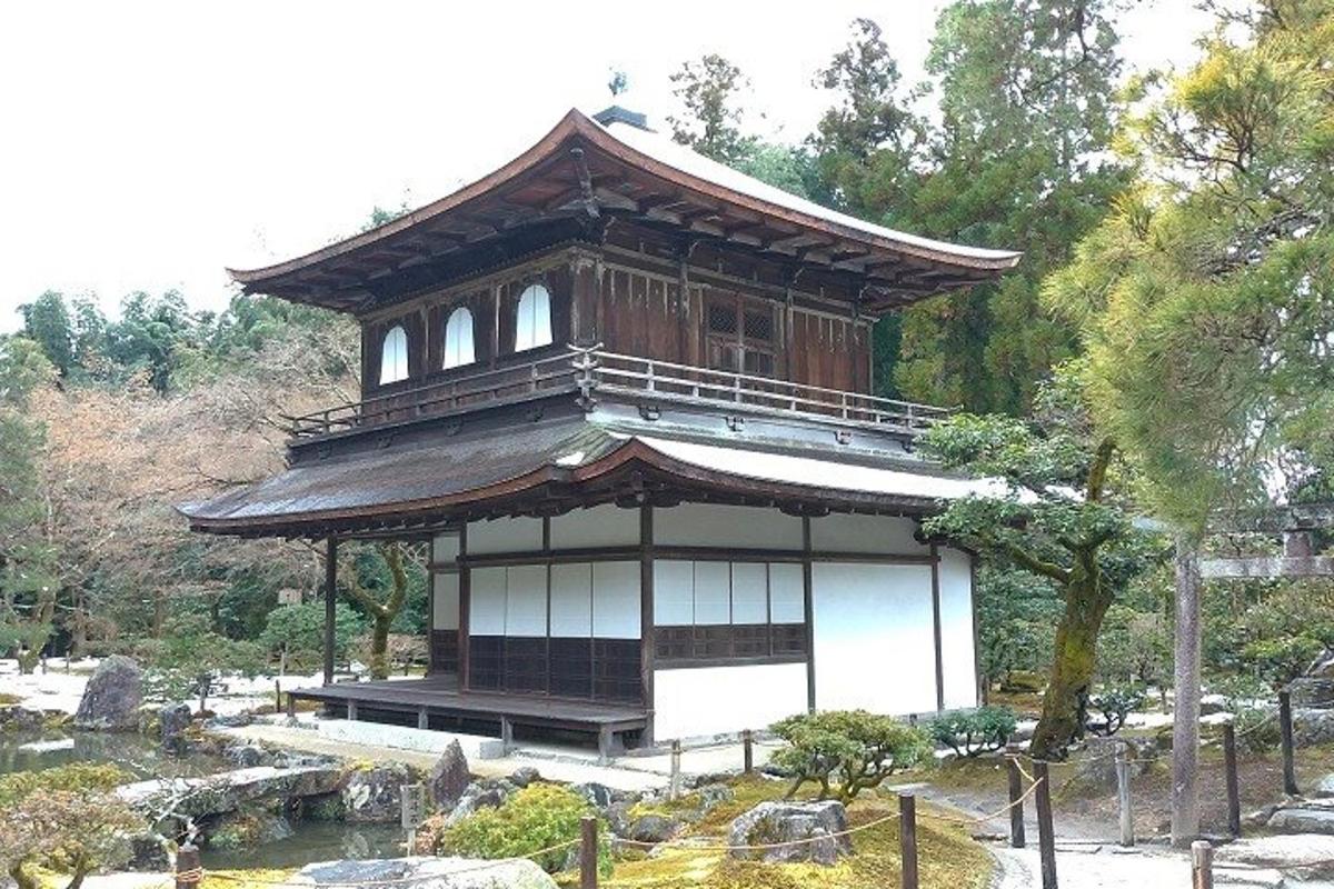 un piccolo edificio in un giardino con uno stagno