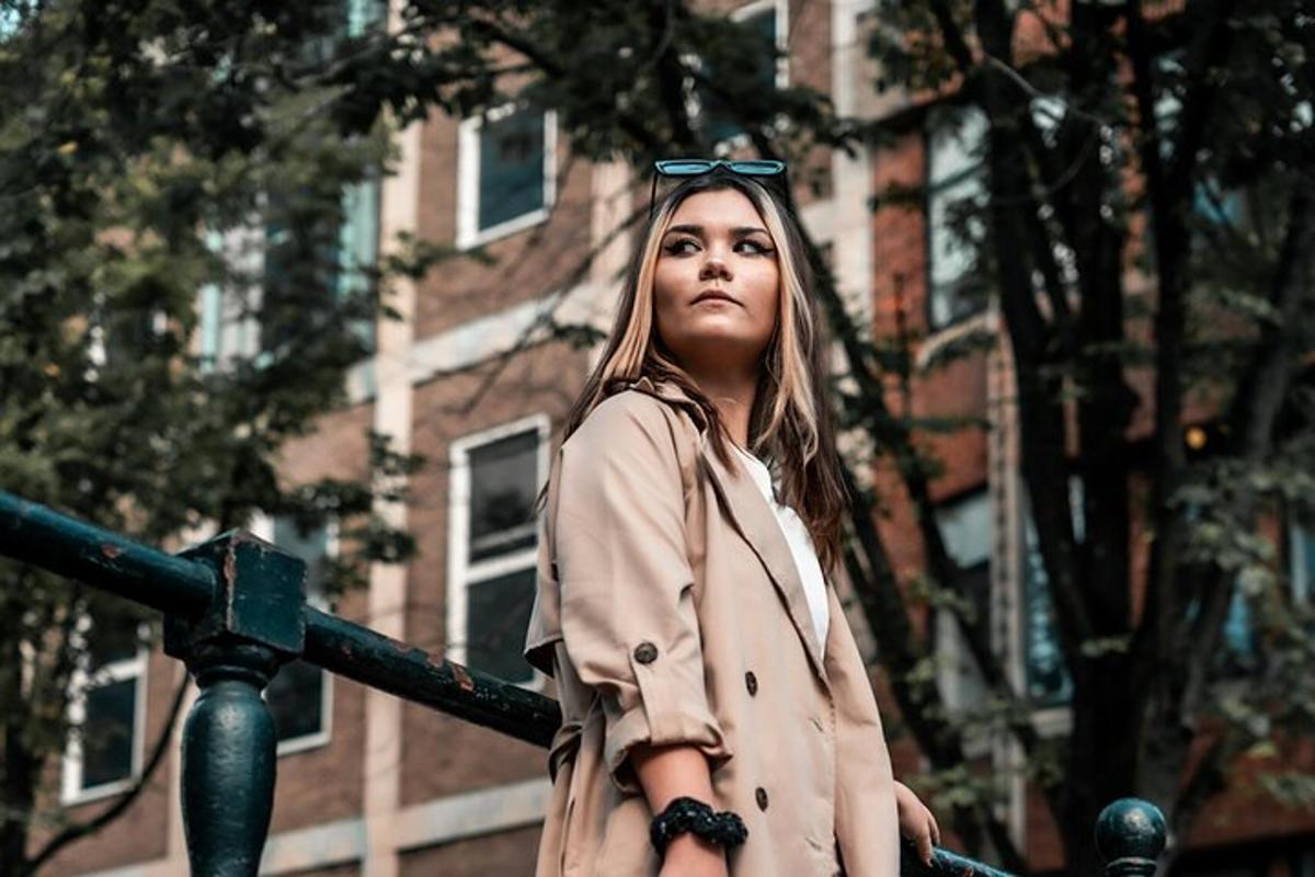 a woman with glasses on her head standing next to a fence