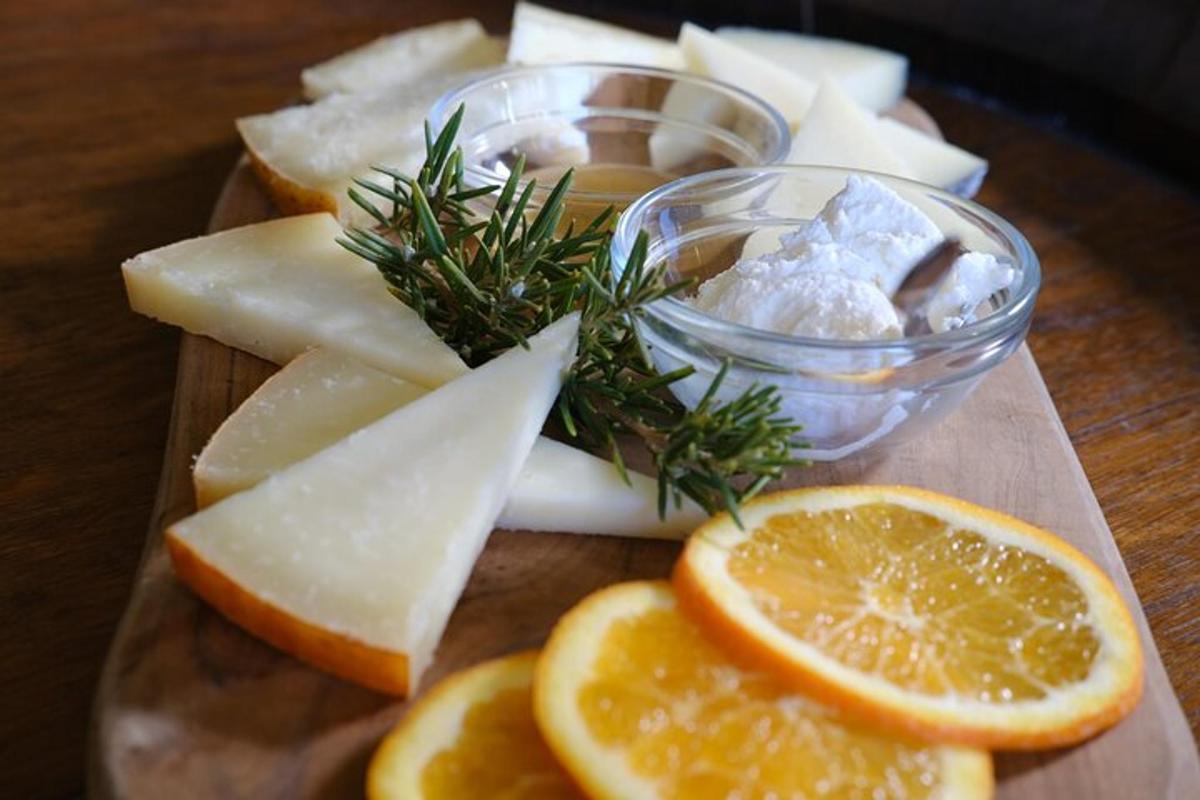 a wooden cutting board with slices of cheese and oranges