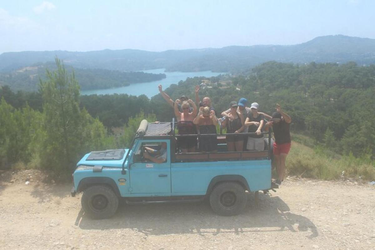 a group of people standing in the back of a blue truck