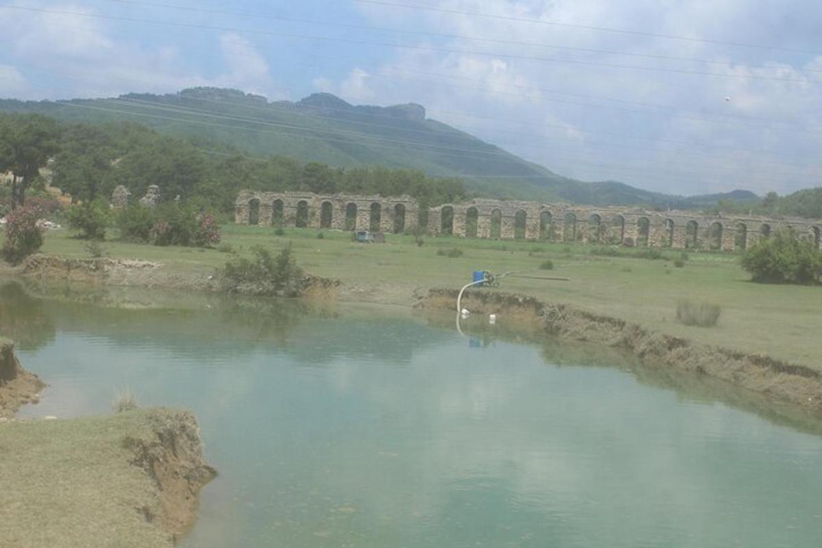 un fiume con un gruppo di colonne in un campo