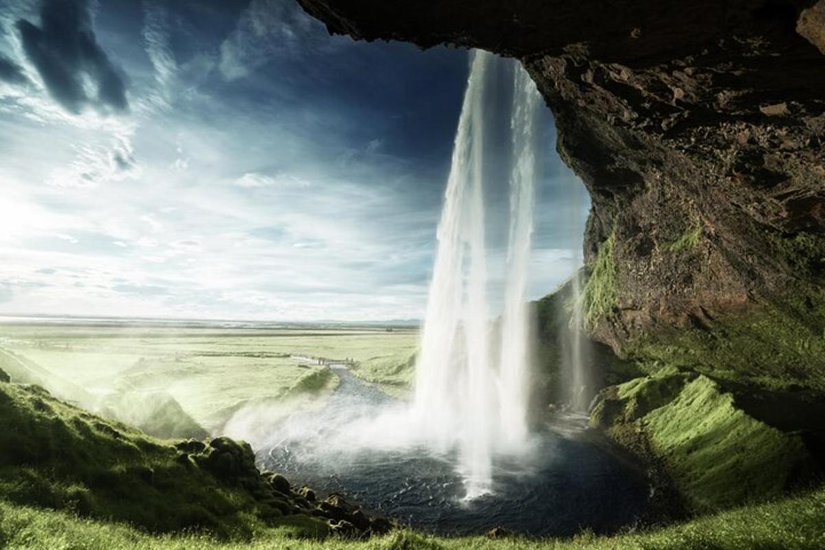 una cascata cade da una grotta nell'acqua
