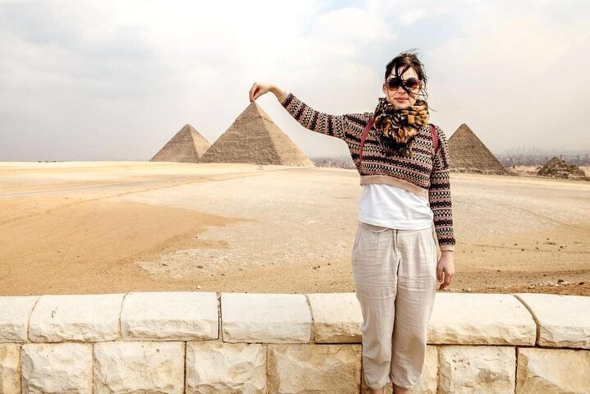 žena stojaca na múre pred pyramídami