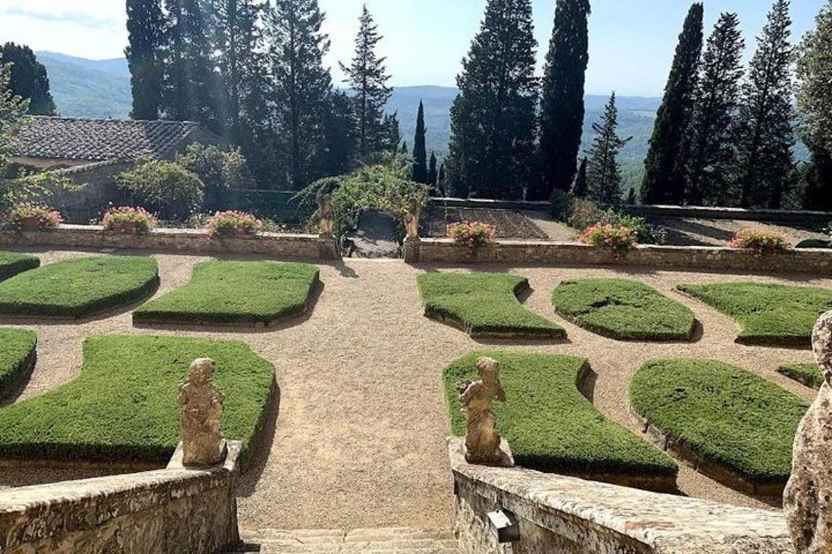 um jardim com grama, sebes e estátuas