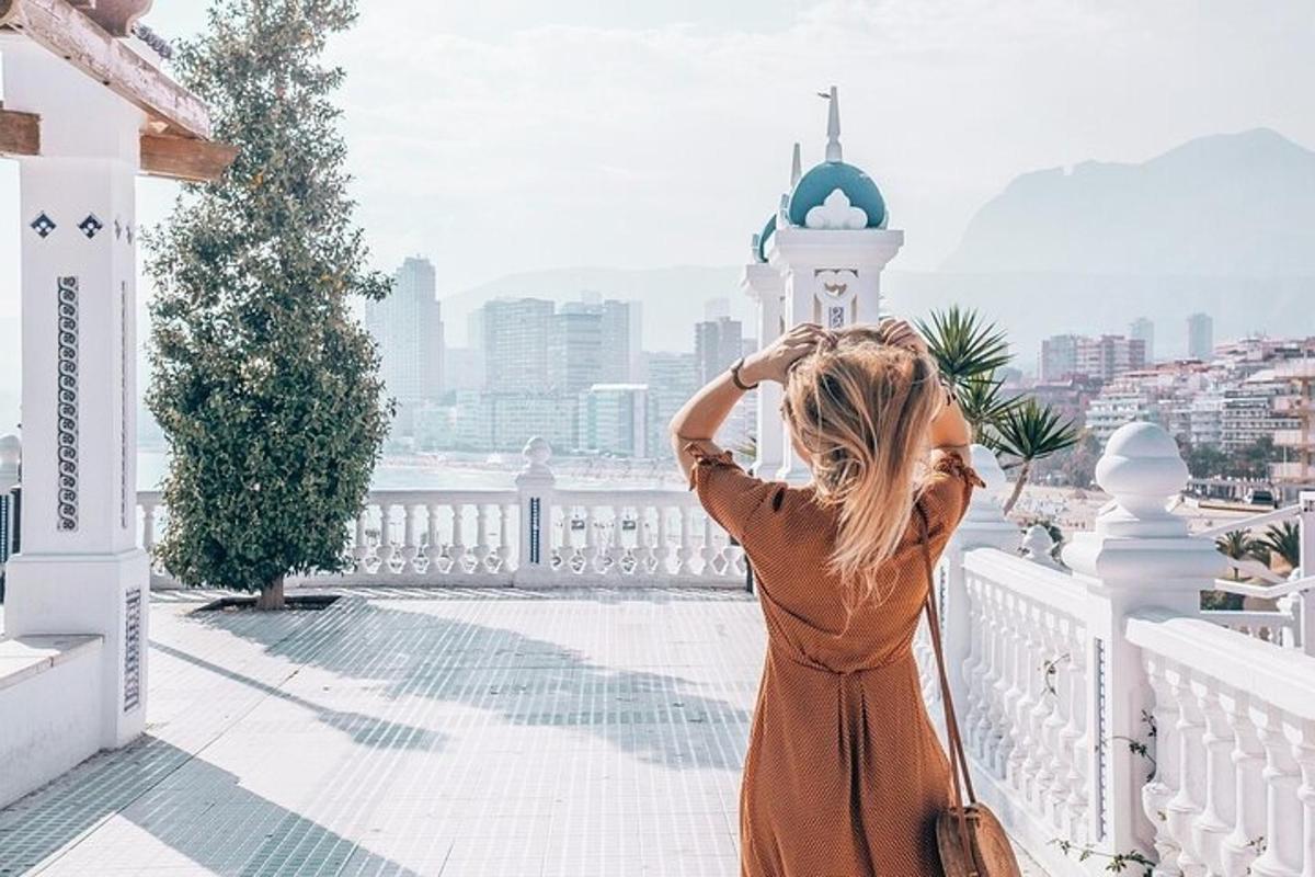 una donna in piedi su un balcone che guarda la città