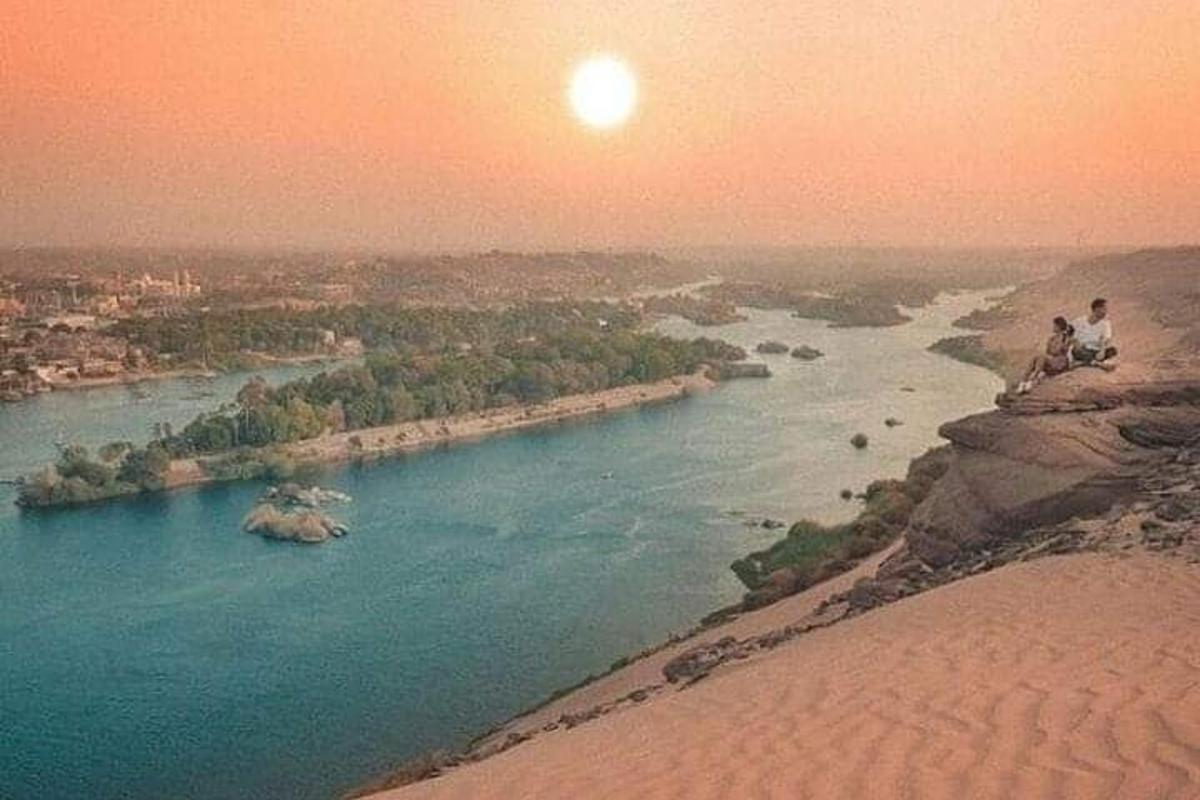 una persona seduta in cima a una scogliera che domina un fiume