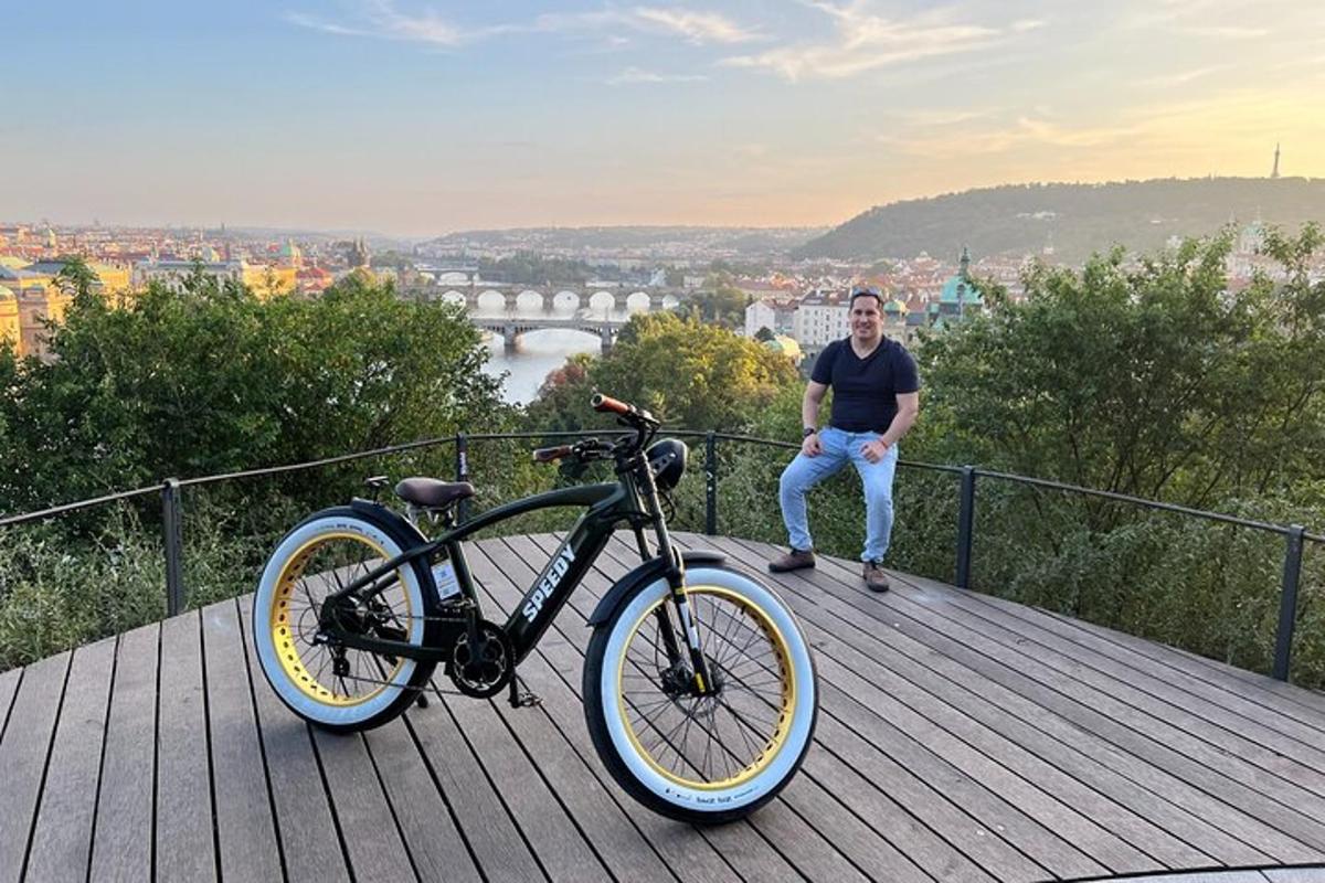 muž sedící vedle kola na dřevěné terase
