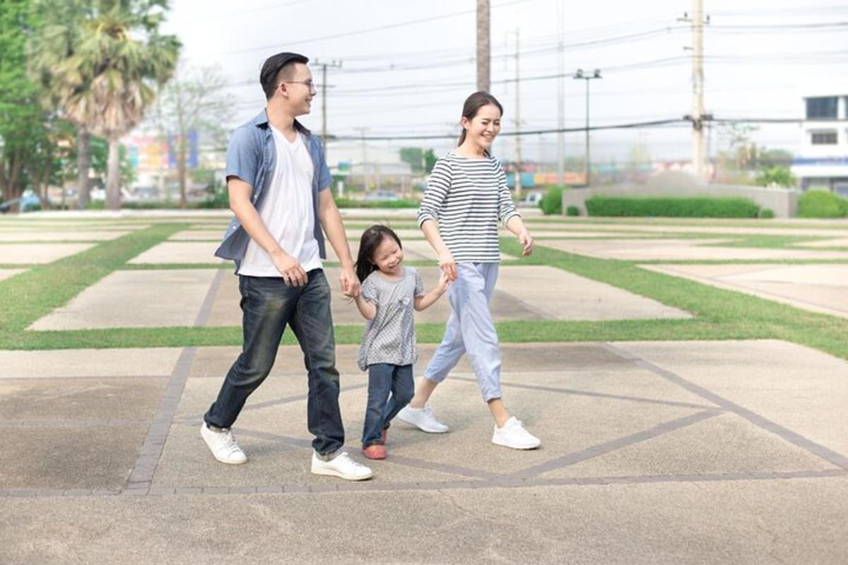 a man and a woman walking with a little girl