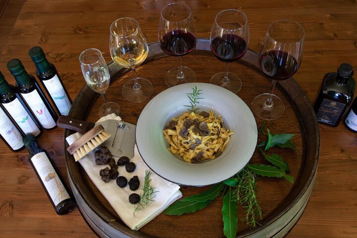 borð með skál af pasta og vínglösum