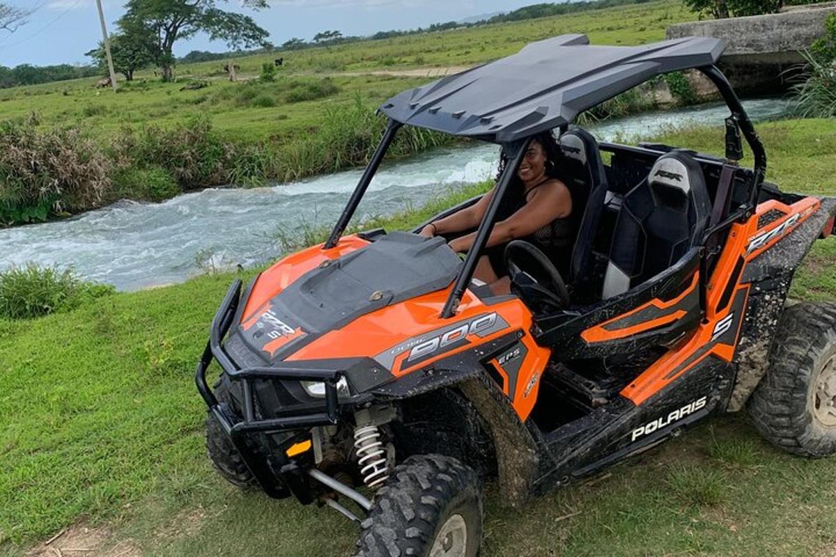 nehrin yanında park etmiş turuncu bir ATV'deki bir kişi