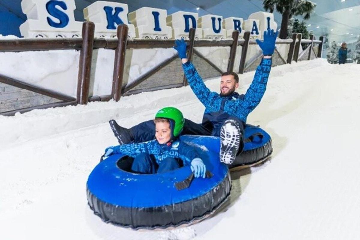 two people are riding on a tube in the snow