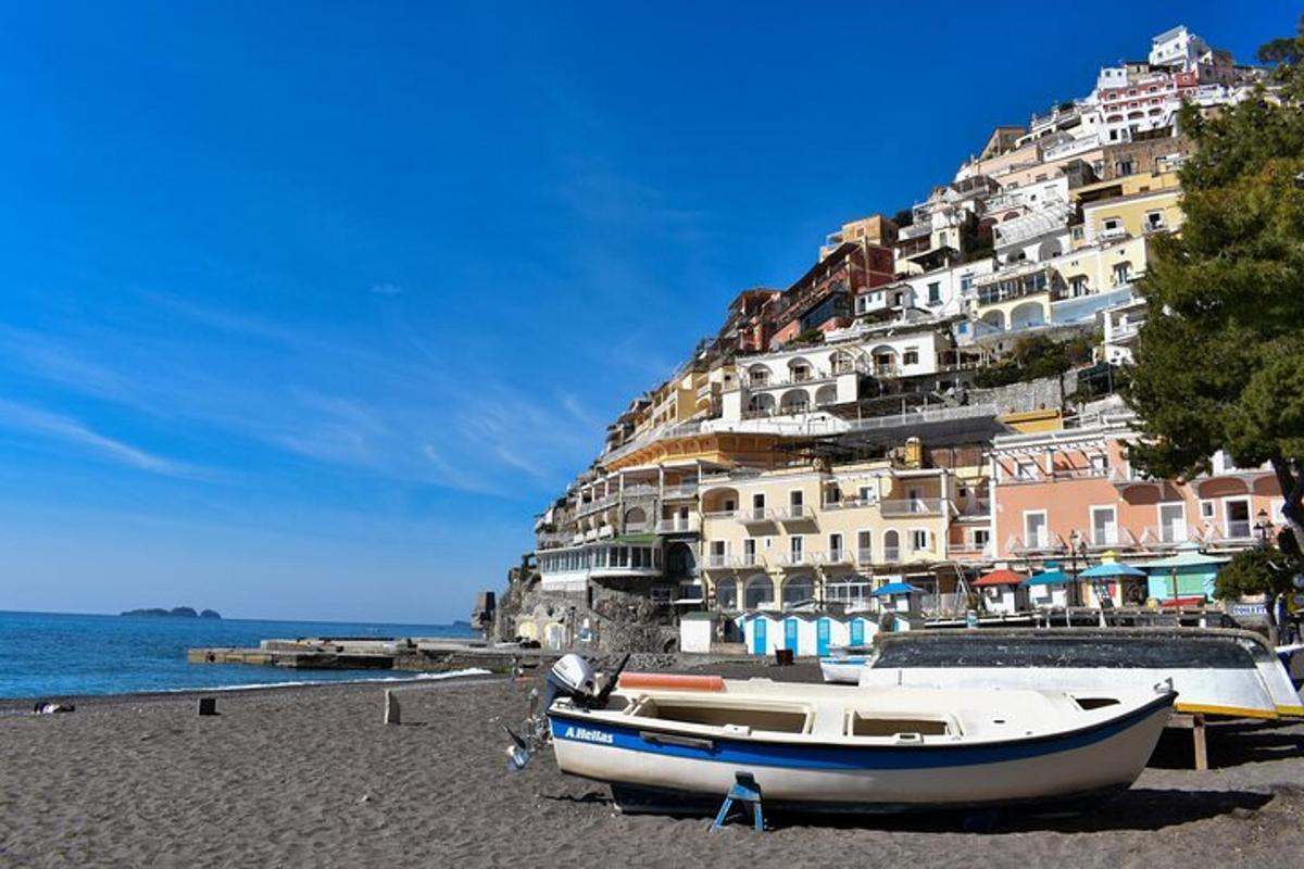 un gruppo di barche sedute su una spiaggia con una montagna