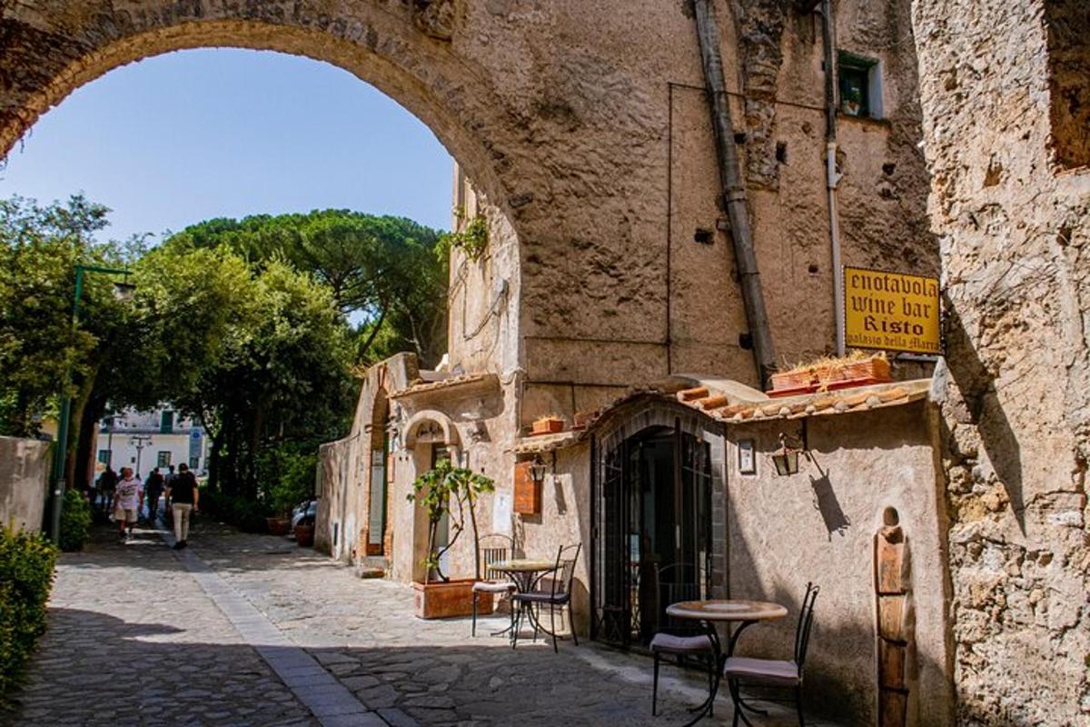 un edificio in pietra con un arco accanto a una strada