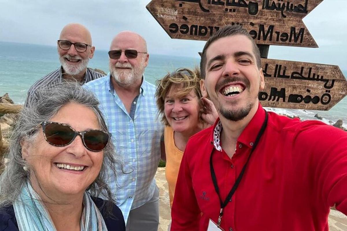a group of people posing for a picture on the beach
