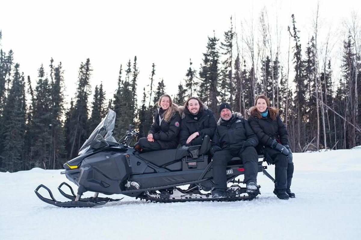 un groupe de personnes assises sur une motoneige dans la neige