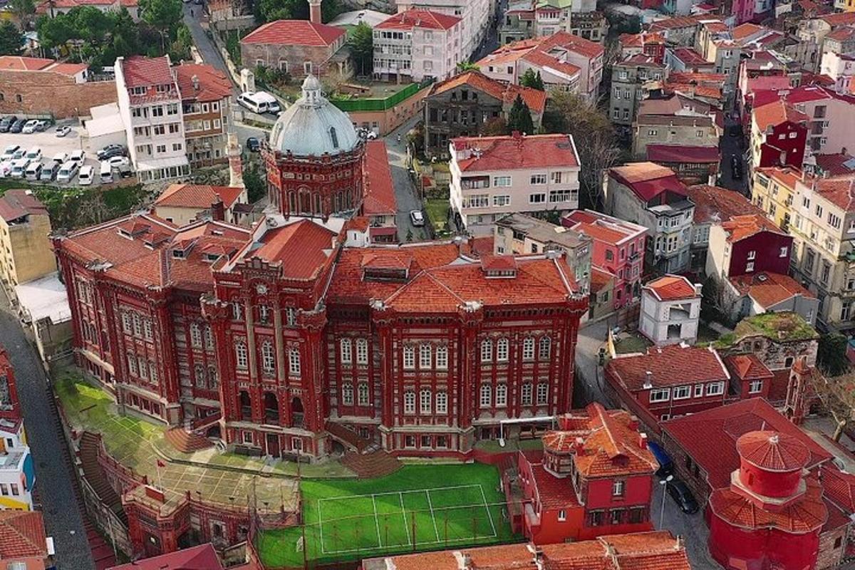 Letecký pohled na velkou červenou budovu s hodinovou věží