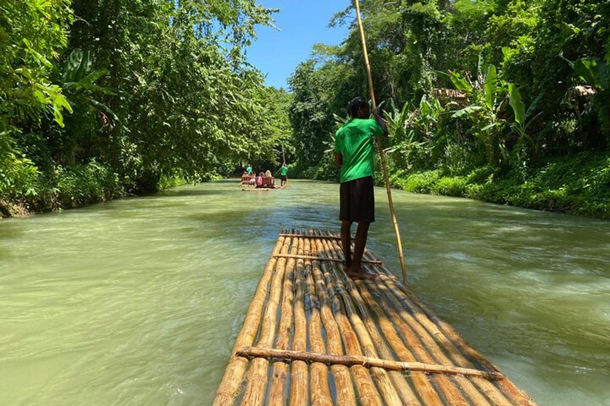 un home dret sobre una bassa de bambú en un riu