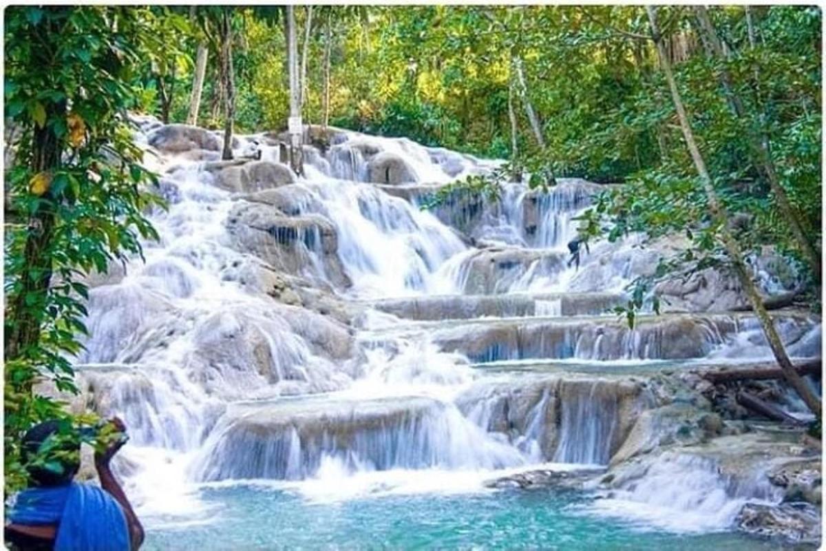 a man taking a picture of a waterfall