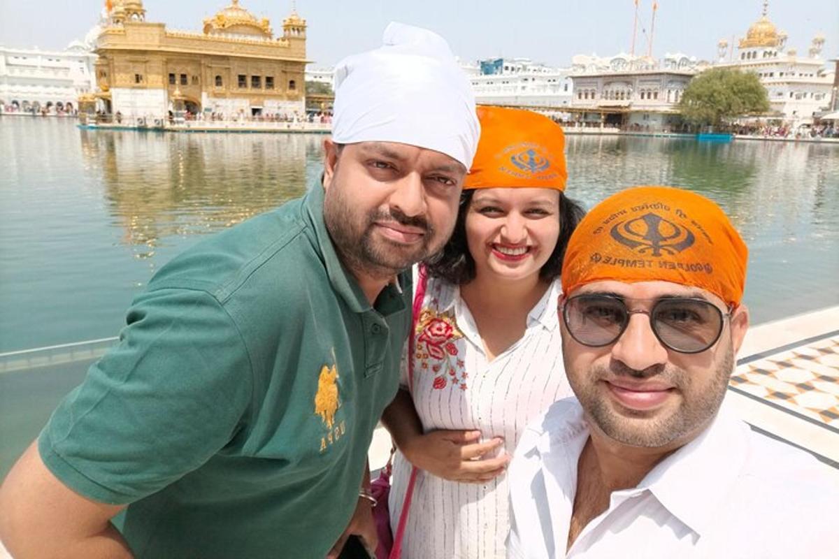 a group of three people standing in front of a body of water