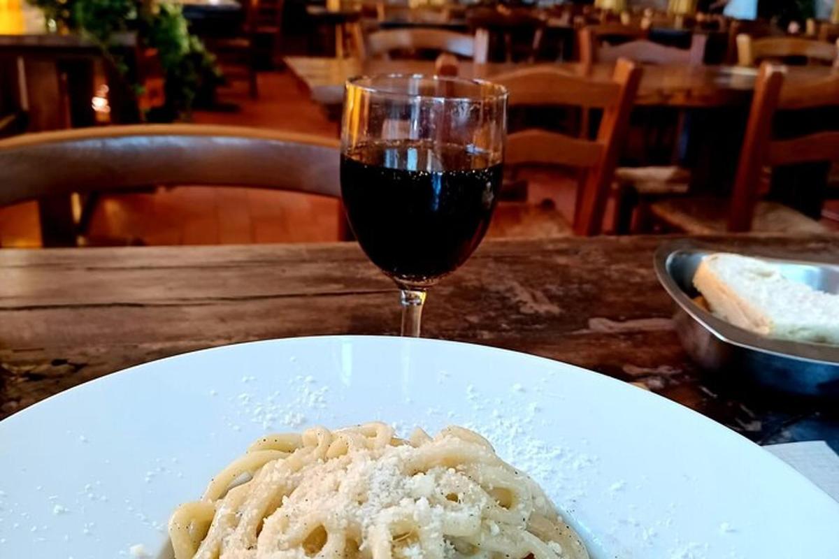 Pastaplata og glas af víni á borði