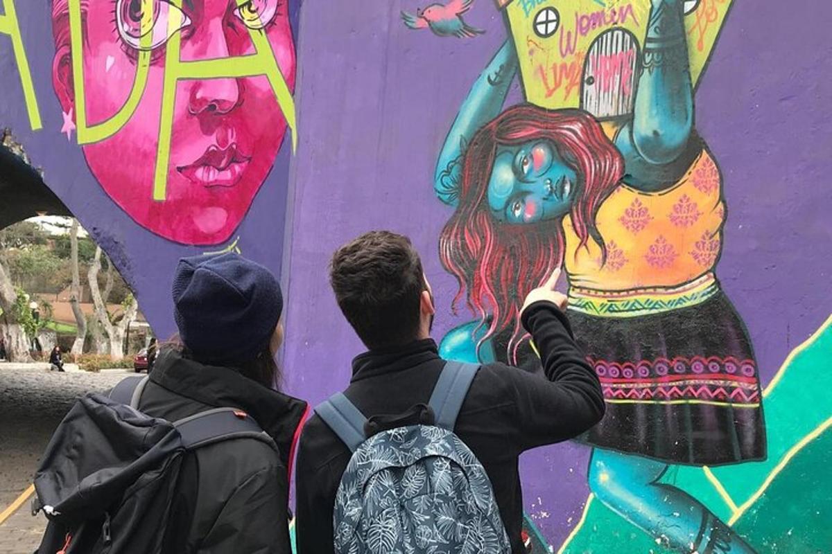 dwie osoby malujące mural na ścianie